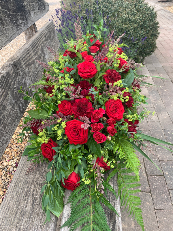 Casket Spray of long stem red and burgundy roses with greenery Funeral Flower delivery to Winchester Undertakers